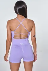 Conjunto deportivo lila compuesto por un top de tirantes con logo 'bk.' y un short de tiro alto. El top es de corte ajustado y tiene textura acanalada. El short es de corte ajustado y tiene cintura alta.