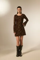 Vestido mini negro de poliéster, entallado, con cuello bote y mangas largas transparentes con estampado floral en relieve.