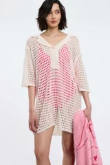 Vestido tejido calado color crudo, con cuello polo, manga corta y corte holgado.