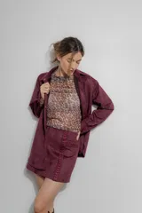 Minifalda color borgoña confeccionada en gamuza sintética con bordado de flechas en la parte delantera.