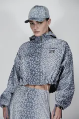 Chaqueta cropped con estampado de leopardo en tonos azules y grises, con cierre frontal y detalle de cordón.