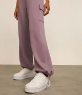 Pantalón deportivo color lila, confeccionado en microfibra pesada con viscosa certificada. Cuenta con cintura elástica ajustable, bolsillos cargo laterales y ajuste en el bajo.