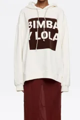 Sudadera oversize con capucha ajustable con cordones, de algodón color crudo con logo Bimba y Lola estampado en marrón. Manga larga con puños ajustados.