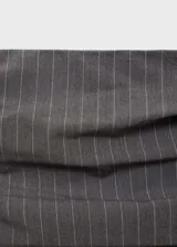 Vestido midi gris con finas rayas verticales blancas, de corte ajustado y sin mangas. Presenta escote strapless, detalle drapeado en la falda y abertura en la parte posterior.
