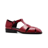 Sandalias de cuero negro con diseño de tiras cruzadas y hebilla lateral. Taco bajo.