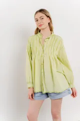Camisa oversize de algodón color verde lima, con cuello mao con volados y pliegues verticales en el frente.