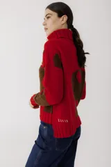 Sweater de punto color verde militar con cuello alto y bordados de hilo color mostaza.