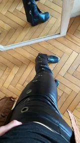 Pantalón negro de gabardina elastizada con ojalillos metálicos plateados a lo largo de la pierna.