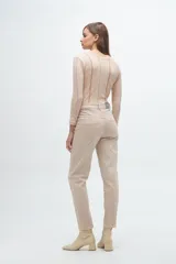 Remera gris de corte ajustado, con cuello redondo y mangas largas. Presenta líneas verticales bordadas en color verde claro y blanco.