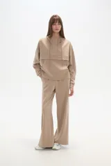 Pantalón deportivo negro de corte holgado, con cintura elástica, bolsillos laterales y botones a presión en las costuras laterales de las piernas.