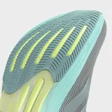 Championes de running Adidas Supernova Rise 2, color gris con detalles en verde menta y amarillo neón en la suela. Presentan una parte superior de malla transpirable y una entresuela gruesa con tecnología Dreamstrike+.