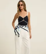 Pantalón pantalona de corte sastrero color blanco, con trabillas en la cintura y pliegues delanteros.