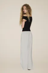 Pantalón palazzo color verde oliva de tejido fluido, tiro medio, cintura elástica ajustable con cordones y bolsillos laterales.
