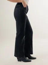 Pantalón de jean azul oscuro, de corte recto y tiro alto, con bolsillos delanteros y traseros. Presenta costuras verticales en el frente.