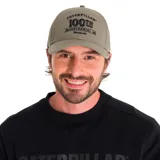 Gorro de gabardina color verde oliva con visera curva y logo bordado en el frente con la leyenda "Caterpillar 100th Centennial Worldwide". Ajuste con hebilla plástica en la parte trasera.