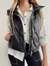 Chaleco puffer de ecocuero negro, con bolsillo, diseño ajustable a los lados y forro interior.