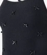 Conjunto de pijama corto negro confeccionado en Rib sin estampa. Incluye blusa con breteles finos, escote nadador en la espalda y aplicación de lazos; y short con cintura elástica y bajo frufru.