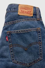 Jean azul de corte recto y tiro alto, con lavado medio y efecto desgastado en los muslos.