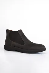 Bota Chelsea de cuero negro con elástico lateral y suela gruesa.