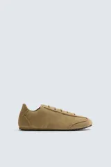 Zapatilla de cordones color beige, con capellada de cuero serraje, cordones de cuero y suela ultrafina.