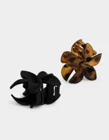 Set de dos broches para el pelo con forma de flor, uno color marrón con manchas negras y otro color negro.