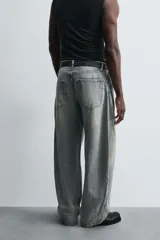 Pantalón de jean celeste con efecto lavado, corte holgado desde la cadera que se estrecha ligeramente en el bajo, tiro medio, cinco bolsillos y cierre frontal con cremallera y botón.