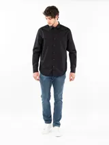 Camisa negra de manga larga con cuello clásico, cierre frontal con botones, bolsillo de parche en el pecho y logo Calvin Klein.