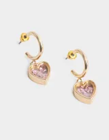 Aros argolla dorados con dije de corazón transparente relleno de confetti con strass rosado.