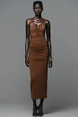 Vestido midi marrón entallado, con escote recto, tirantes y detalle de caracola metálica en los tirantes.