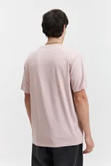 Remera de manga corta color rosa pálido con estampado circular en el frente.