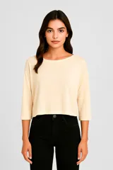 Remera color crema de corte crop, con cuello redondo y mangas 3/4.