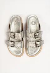 Sandalias marrones de cuero vacuno con doble tira y hebillas metálicas ajustables.
