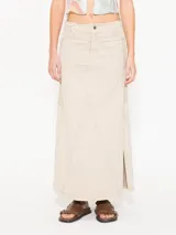 Pollera midi color beige con recortes en combinación de tejido en laterales, recortes en frente y espalda; y tajos en los laterales.