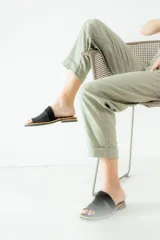 Sandalias de cuero negras con diseño de tiras cruzadas y detalle de elástico en el talón.