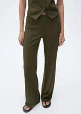 Pantalón de punto color verde militar, de tiro medio y corte recto. Presenta cintura elástica, costuras decorativas frontales y diseño largo.