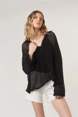 Pullover negro de malla con cuello polo acanalado y mangas largas holgadas.