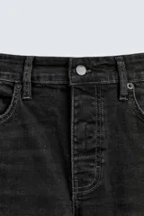 Pantalón de jean azul oscuro con efecto lavado y roturas en las rodillas, de corte ajustado al cuerpo desde la cintura hasta el tobillo.