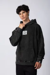 Buzo canguro negro con efecto gastado y estampa cuadrada con diseño abstracto en el pecho. Corte oversize con capucha y puños ajustados.