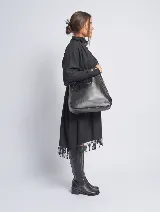 Bandolera negra de cuero sintético con correa ajustable y bolsito mini desmontable en su interior.