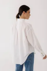 Camisa blanca de algodón con pespuntes cobrizos y detalle de volado en mangas y cuello.