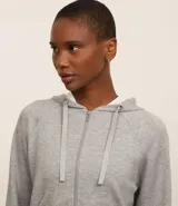 Campera deportiva verde esmeralda de modal, con capucha ajustable con cordón, cierre frontal con cremallera y bolsillos laterales.