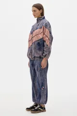 Campera estilo olímpica de jean con lavado gastado en azul y rosa. Corte oversized, con elástico en la cintura y bolsillos al frente con cierre.