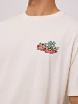 Remera color crema de algodón con estampado en la espalda de un tiburón con gafas de sol, palmeras y texto "Easy life in the City of Palm Rusty 1985".