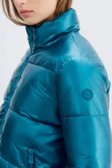 Campera puffer metalizada color azul petróleo, con cuello alto, cierre frontal y bolsillos con cierre. Tiene ajuste interno en el ruedo.
