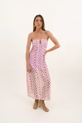 Vestido largo de crochet color lila y beige con breteles finos cruzados en la espalda y escote en V. El forro es corto, dejando ver las transparencias del tejido.