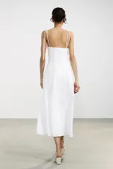 Vestido midi amarillo claro, con escote corazón con volantes y tirantes finos ajustables con lazo. Falda acampanada con forro interior.