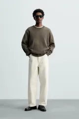 Pantalón de jean negro de corte amplio y tiro alto, con cinco bolsillos y cierre frontal con botón.