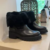 Bota de cuero color marrón con interior de piel sintética, caña media con hebilla lateral y suela de goma track.