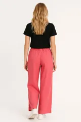 Pantalón de lino color beige, de corte ancho y tiro alto, con bolsillos laterales y cintura elastizada con cordón ajustable.