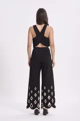 Conjunto de top crop y pantalón palazzo negros con bordados calados en forma de rombos con borde festoneado en color crudo.